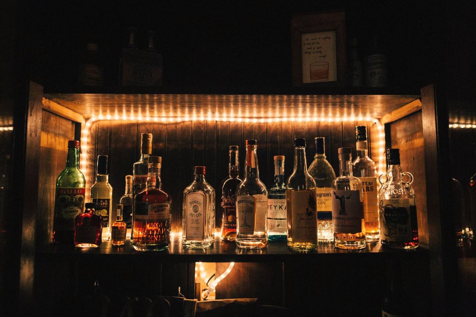 A back bar lit warmly, with bottles on the shelves