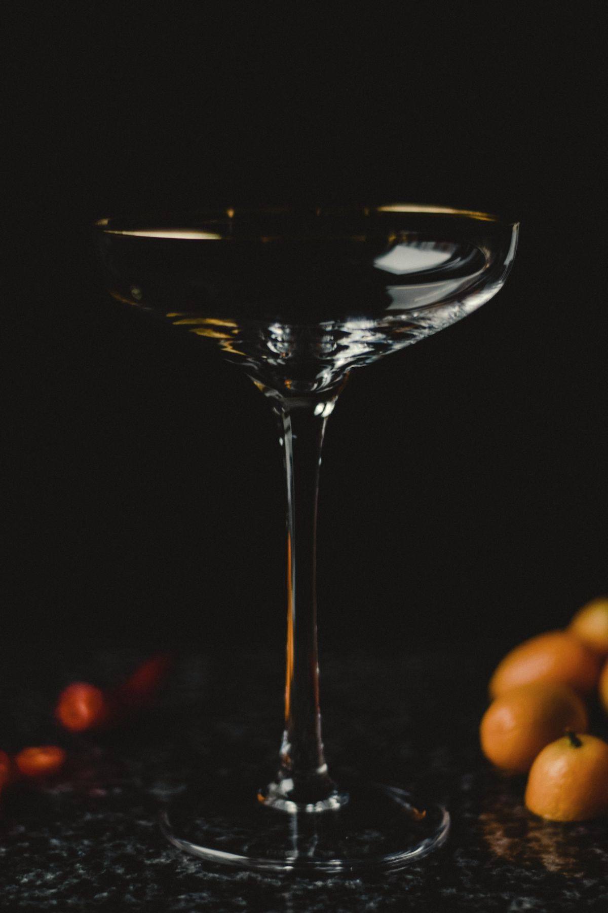 A single coupe glass on a dark stone surface