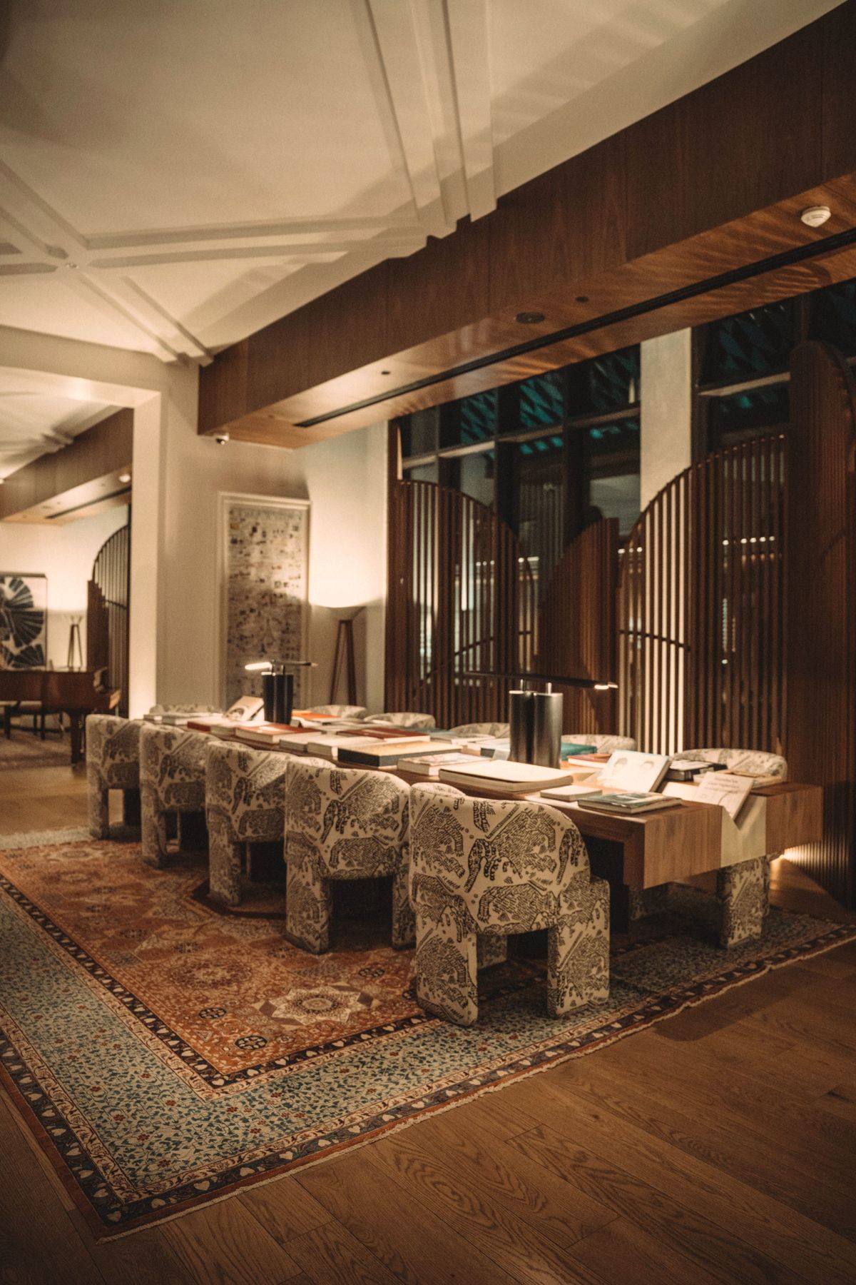A daylit hotel restaurant with a long table and patterned rug